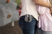 Load image into Gallery viewer, Satchel in Dusk color on woman&#39;s hip belt clip, hugging girl. 