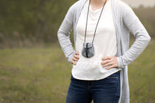 Load image into Gallery viewer, Satchel in Dusk color on woman&#39;s neck. White tee, gray cardigan, jeans. 
