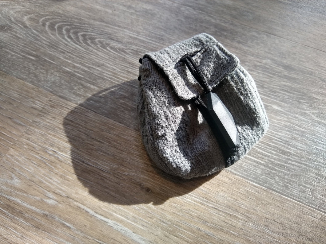 Necklace satchel on gray wood background. Dusk. 